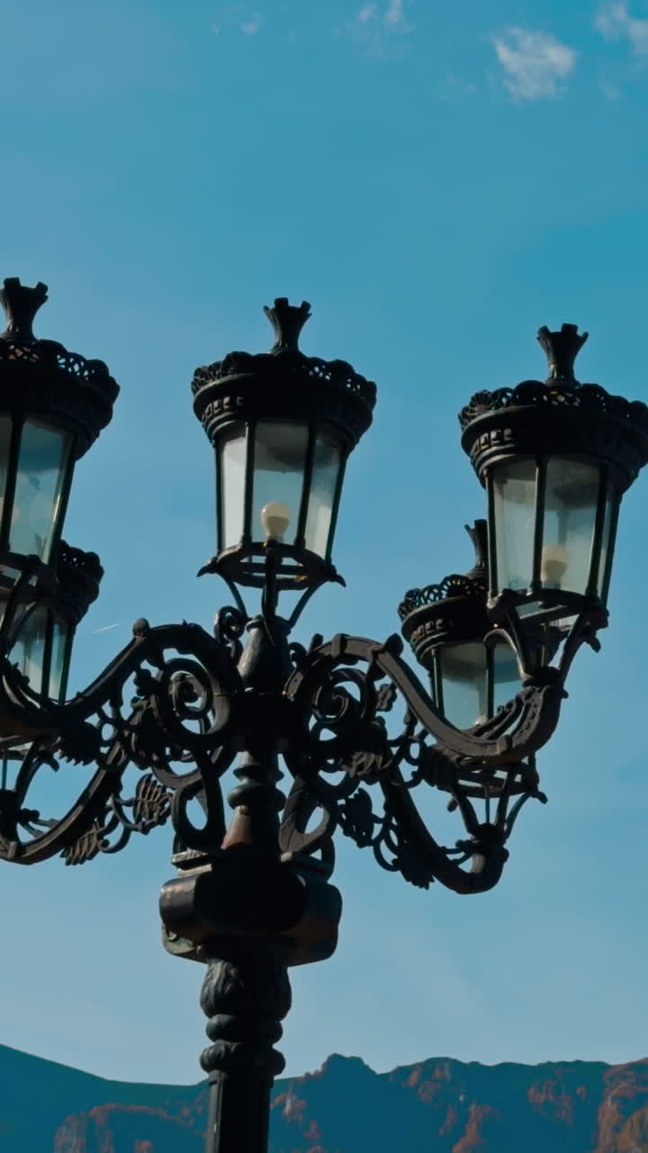 Beautiful black old-style street lantern. Autumn nature and hazy mountains at backdrop. Vertical video