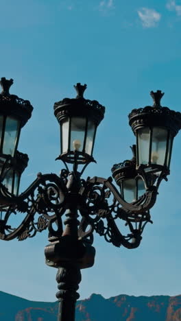 beautiful black old-style street lantern. autumn nature and hazy mountains at backdrop. vertical video