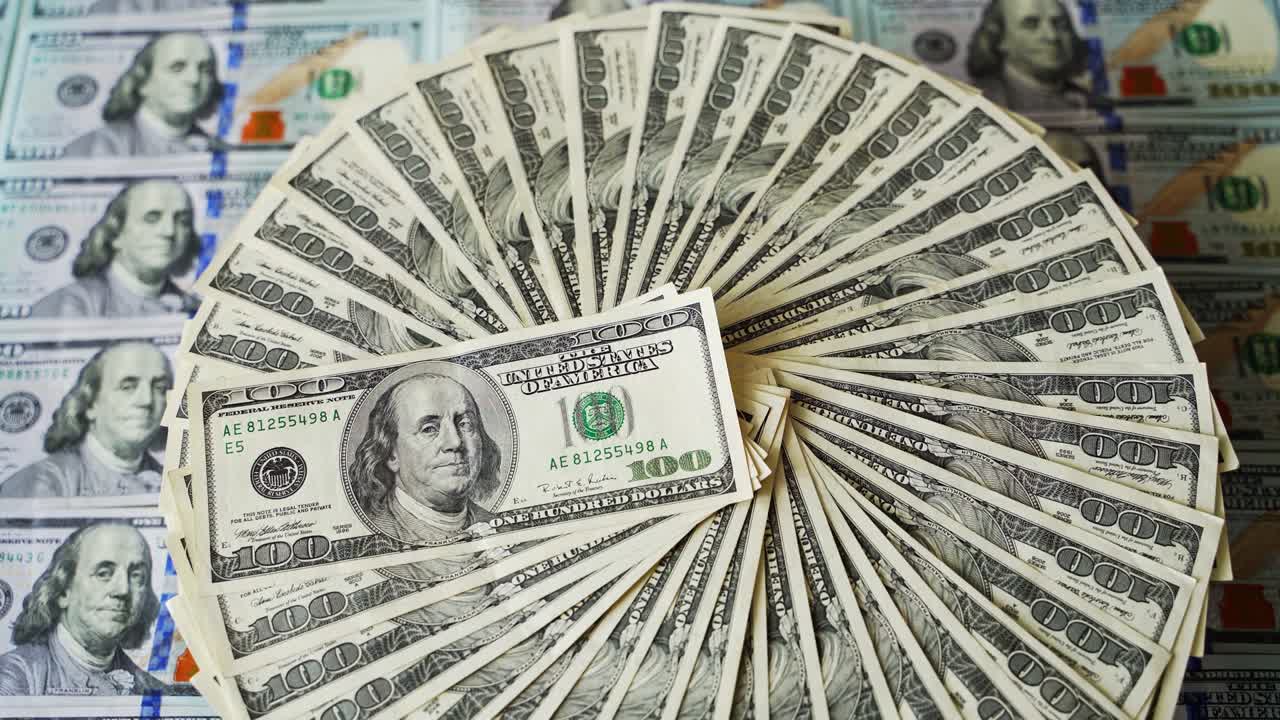 fondo rico de dólares. billetes de cien dólares girando en un círculo. dinero estadounidense en la mesa. moneda del dólar girando.