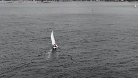 cinematic drone clip over a stormy weather and sea with a saiship moving forward