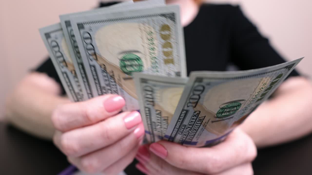 dólares en las manos de una mujer, la chica cuenta billetes, dinero de papel. presupuesto familiar, pago de facturas
