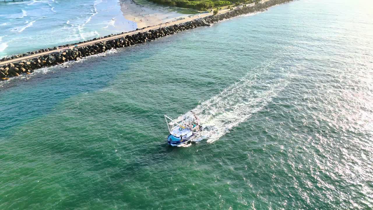 해가 지는 동안 바다 물을 항해하는 트롤러