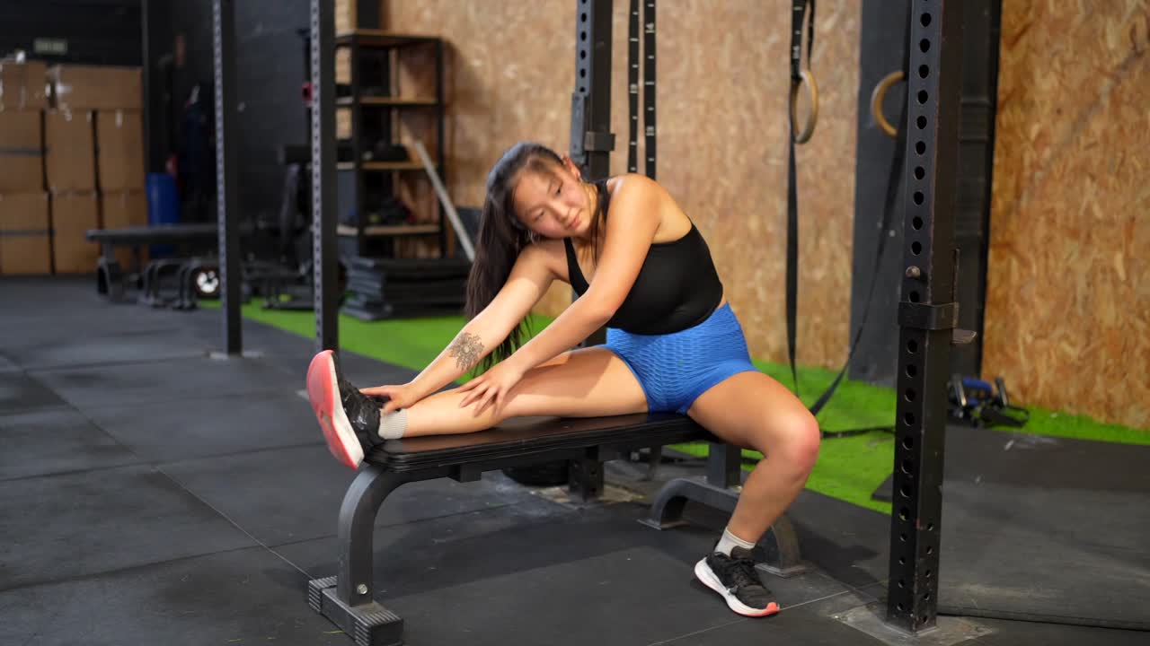 mujer estirándose en el gimnasio