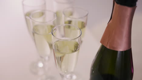 top view of a champagne bottle and crystal glasses with champagne on a table at a bachelorette party