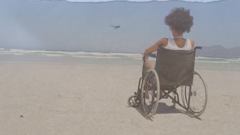 animation of sea landscape over disabled african american woman sitting in wheelchair