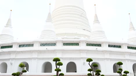 una tranquila exploración de la arquitectura de wat prayurawongsawat en bangkok, mostrando sus icónicas pagodas blancas bajo la suave luz del día