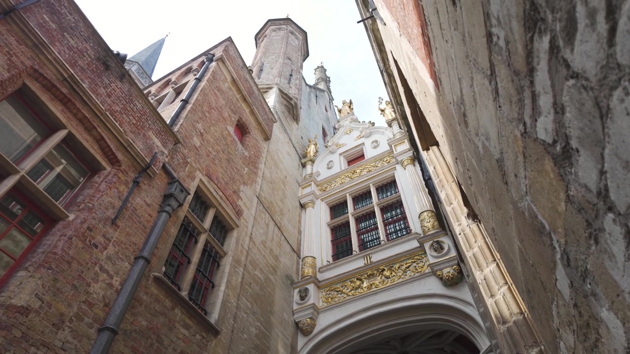 Exteriér historické radnice v Bruggách s krásnou architekturou a bohatými detaily.
