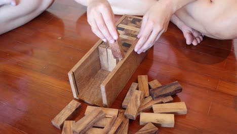 hands stacking and toppling wooden blocks