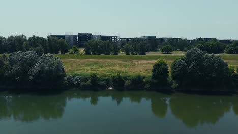 drone shot of unfinished hospital buildings hidden behind trees near sava embankment in zagreb