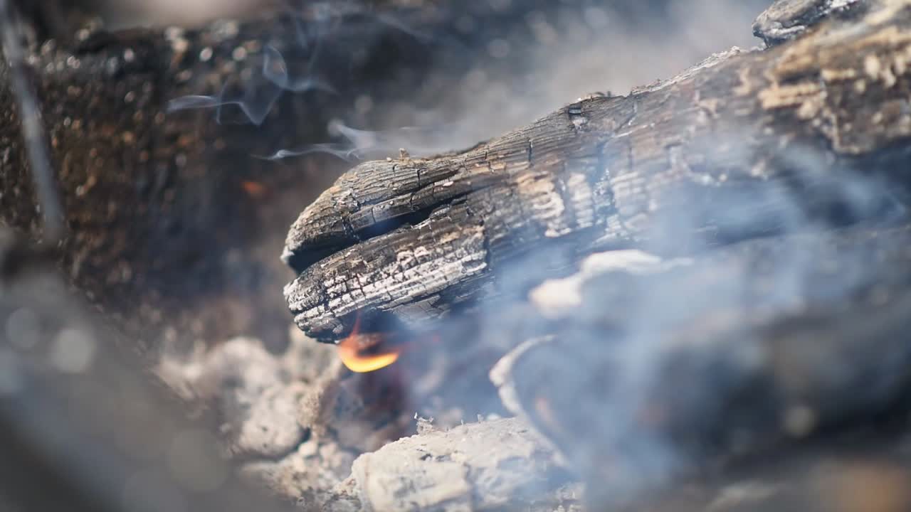Charcoal and wood burn in the barbecue grill. Slow motion shot. Close up