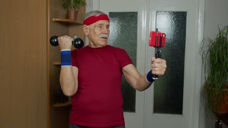 un anciano con una camiseta roja está haciendo ejercicio en casa con una banda de resistencia