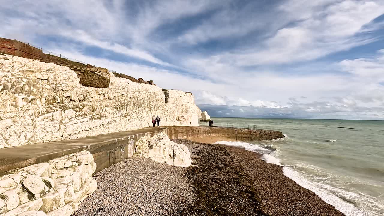 gente caminando por los acantilados del mar