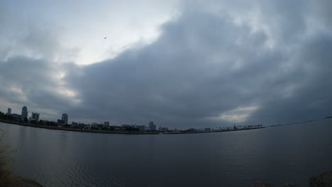 Dramatic-cloudscape-over-the-ocean-with-the-silhouette-of-the-Long-Beach-skyline-in-the-background---sunrise-time-lapse