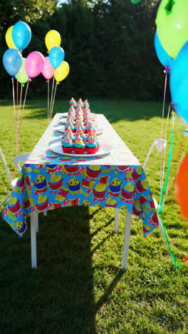 outdoor birthday party with cupcakes and balloons