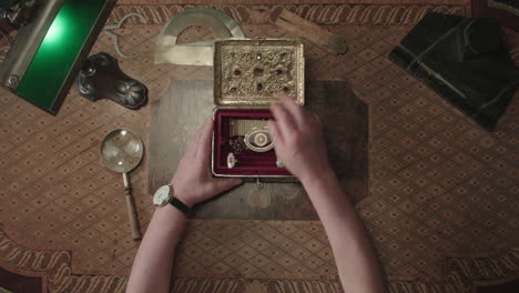 an older man evaluates antique box