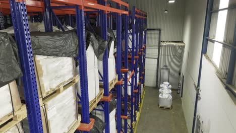 inside a warehouse: many shelves laden with neatly stacked pallets