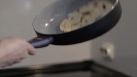 volteando un panqueque en una sartén