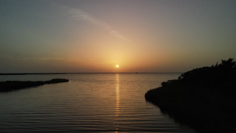 puesta de sol sobre la bahía con pájaros volando