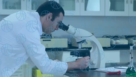 Multiple-basketball-icons-floating-over-caucasian-male-scientist-using-microscope-at-laboratory