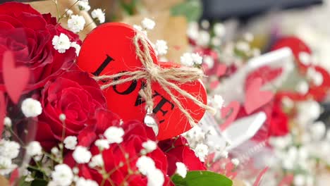 un ramo de rosas rojas con un corazón de madera