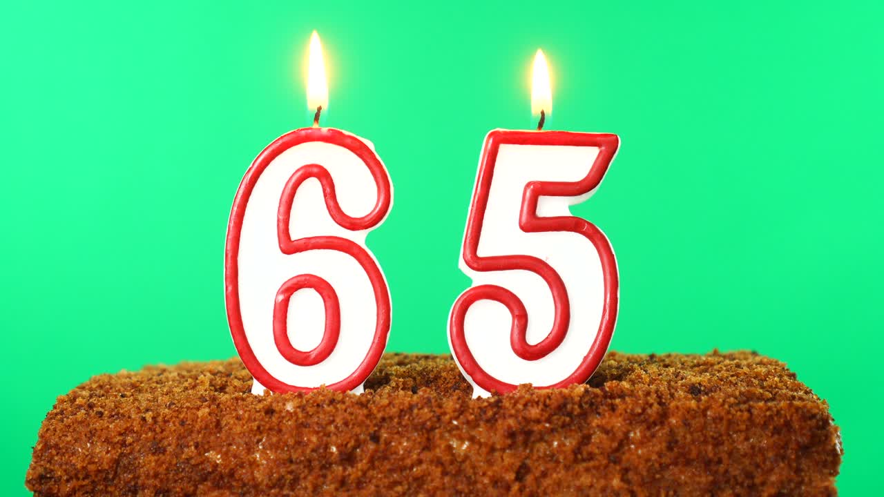 pastel con el número 65 vela encendida. llave de croma. pantalla verde. aislado