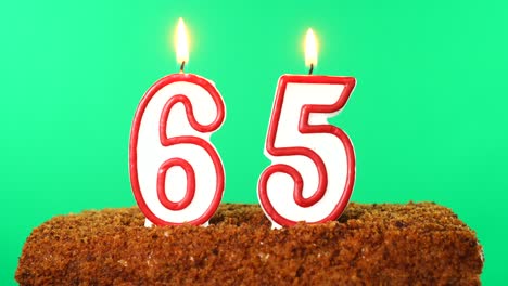 cake with the number 65 lighted candle. chroma key. green screen. isolated