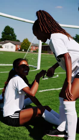 youth female soccer players bonding on the field