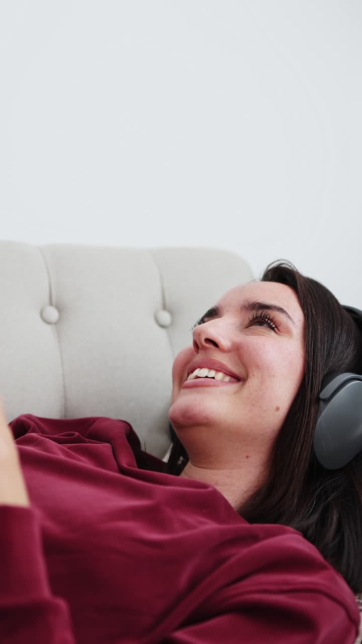 Giovane donna sorridente che ascolta musica con le cuffie