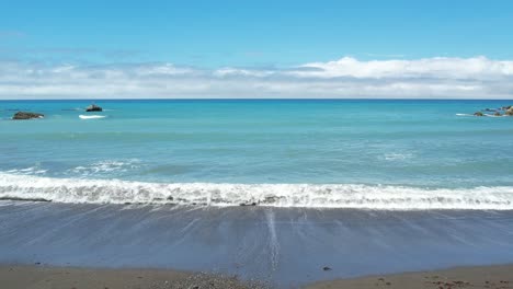 drone hovering while wave washes ashore