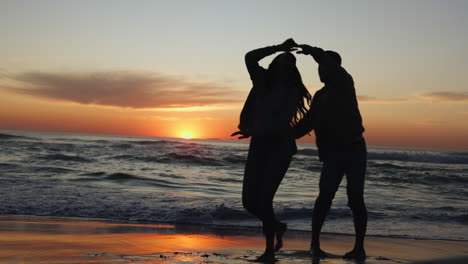 Sunset,-dancing-and-couple-on-a-beach-for-vacation