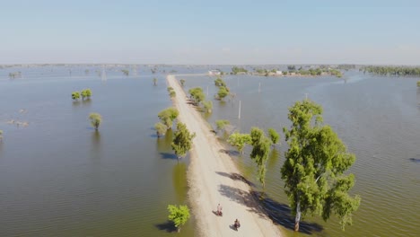 Antenne-Entlang-Einer-Einsamen-Straße,-Umgeben-Von-Hochwasser-In-Den-Horizont-In-Jacobabad,-Sindh