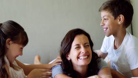 Mother-having-fun-with-her-children-on-bed-at-home