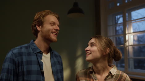 happy couple celebrating in new house. family laughing in renovated home.