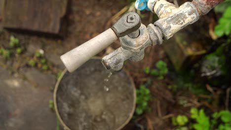 water from the tap drips into the old saucepan 03