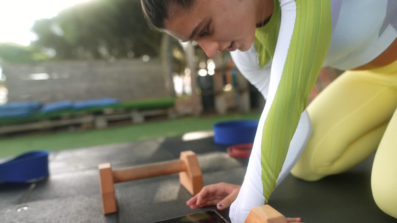 Young Woman Using Smartphone During Outdoor Fitness Training