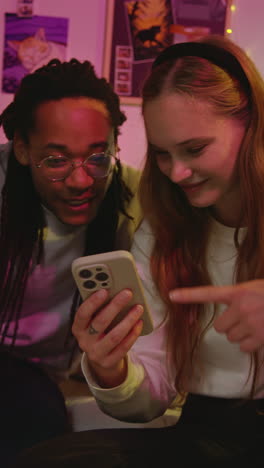 um casal feliz a olhar para o telemóvel.