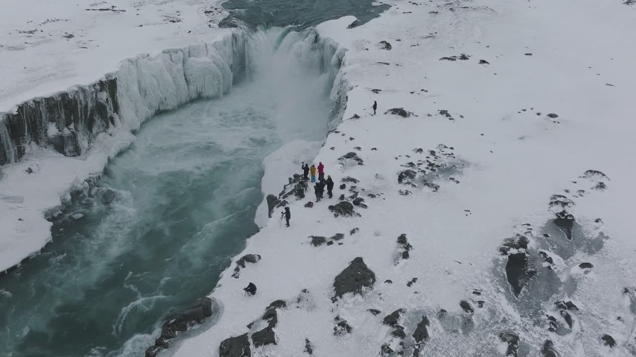 아이슬란드의 데티포스 폭포로 눈 덮인 탐험을 하는 사진작가 관광객 - 항공