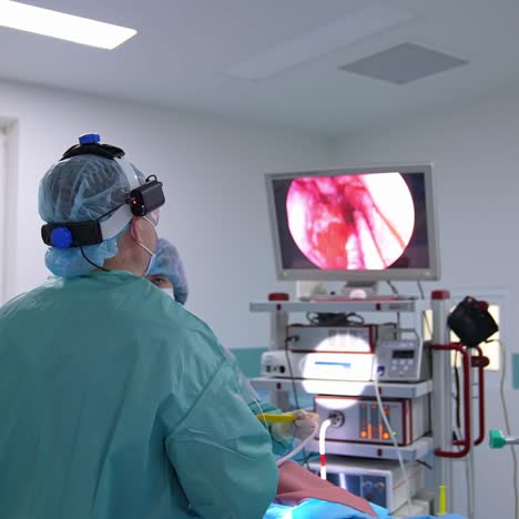 surgeon otolaryngologist put the device into patient's nose. doctor checks the condition of a patient's organs during the operation