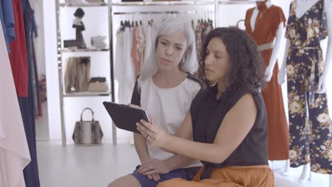 cheerful shop assistant meeting with client on the store with a tablet computer