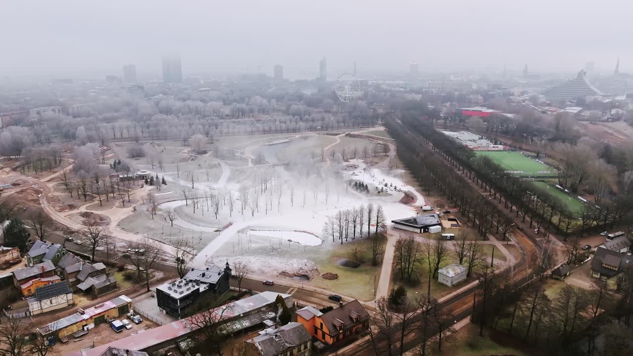 Aerial over Victory Park Riga where snow cannons create ski trail in grey winter