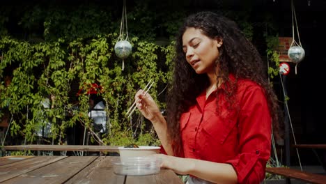 woman eating asian food outdoors