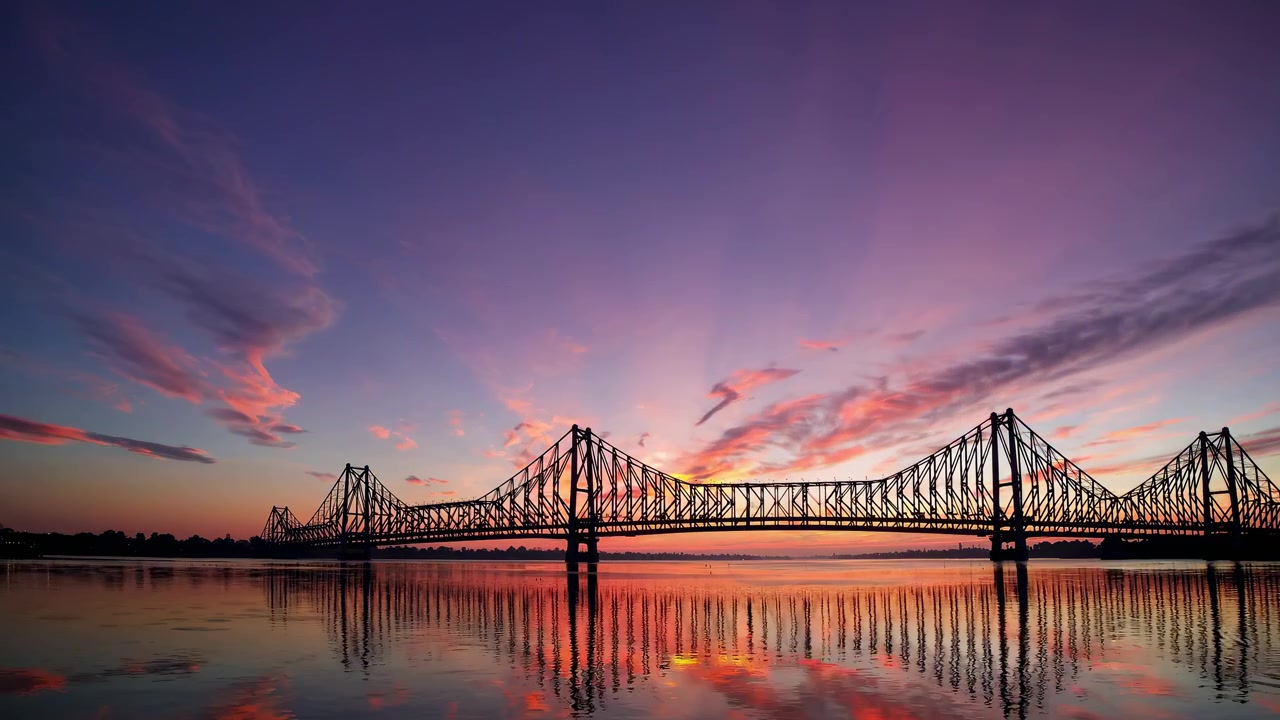 Time lapse di un tramonto su un grande ponte a traliccio in acciaio