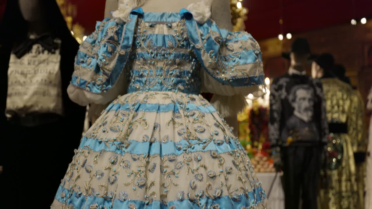 Close-up view of exquisite vintage dresses with intricate beading and embroidery, showcasing historical fashion and craftsmanship.