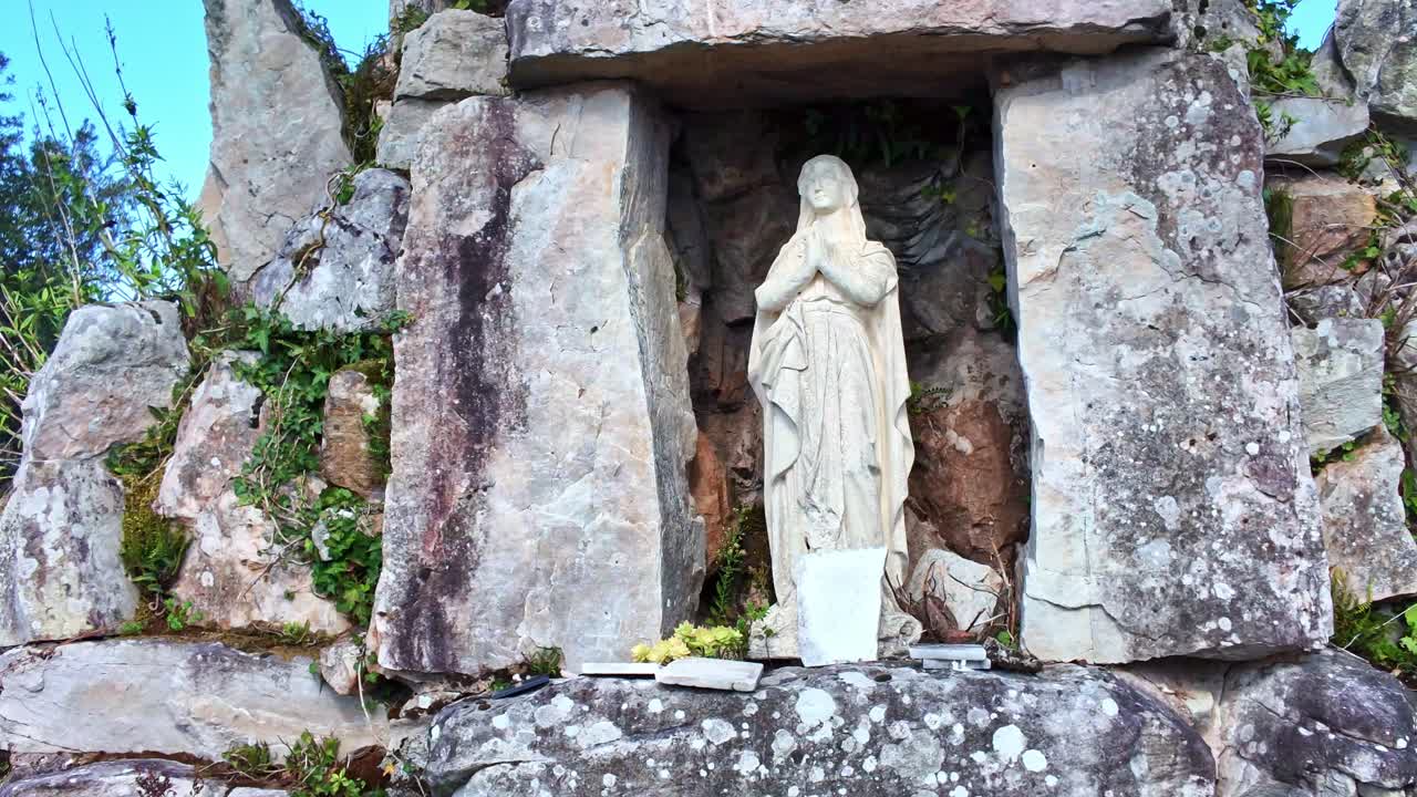 Still view of Virgin Mary statuette in stone niche on building wall in Laval, France