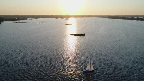 velero en el lago elfhoeven durante la puesta de sol en reeuwijk, holanda del sur, países bajos