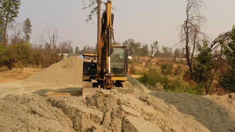 Front-view-of-a-yellow-metallic-excavator-isolated-at-a-construction-site