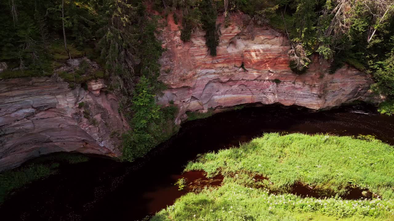 Drone footage from Taevaskoja reveals massive sandstone walls a calm river and endless green trees showcasing one of Estonia’s most iconic and serene natural attractions for travelers
