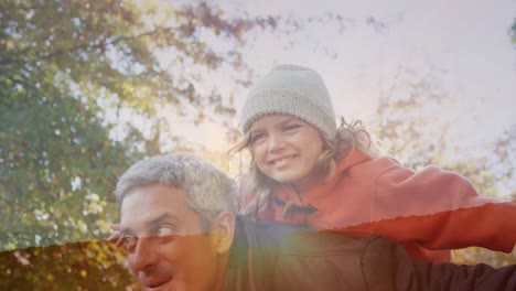 animation of landscape over happy biracial father carrying his daughter