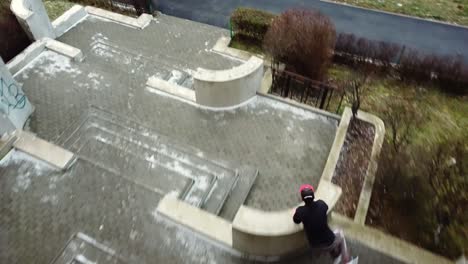 Tiro-De-Seguimiento-Estabilizado-Siguiendo-Detrás-De-Un-Corredor-Libre-De-Parkour-Macho-Adulto-Joven-Que-Salta-Sobre-Múltiples-Paredes