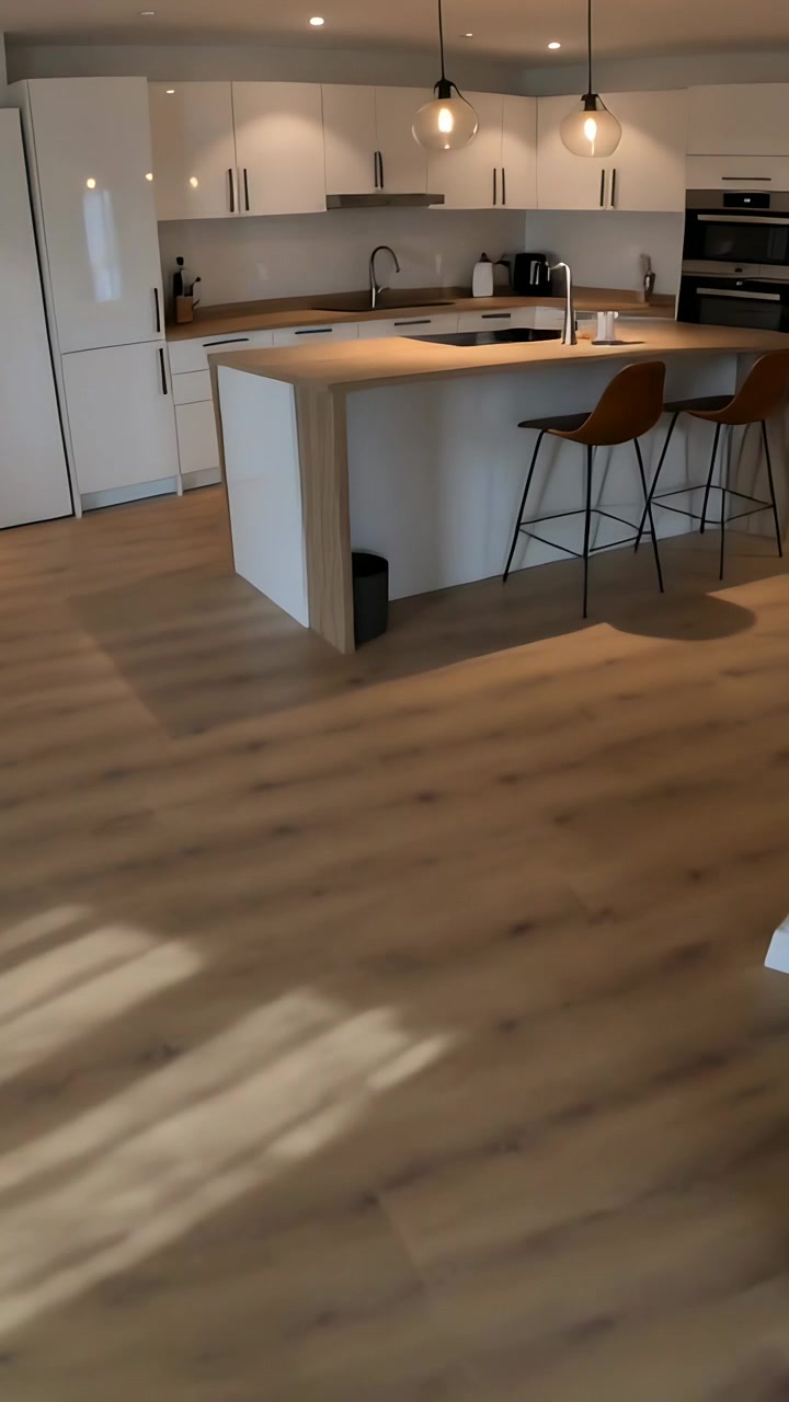 Video verticale: Registrazione di una persona che cammina con una manica blu, che filma con il telefono attraverso l'appartamento, mostrando l'isola della cucina.